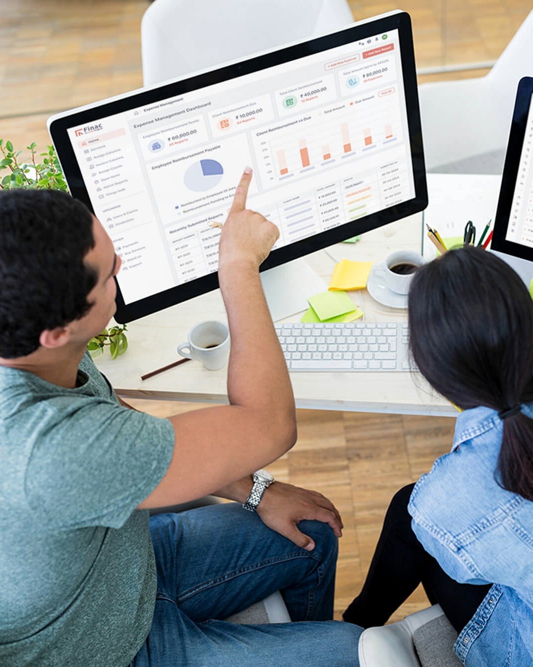 A Finac account manager pointing at the expense dashboard on screen while reviewing it with a client